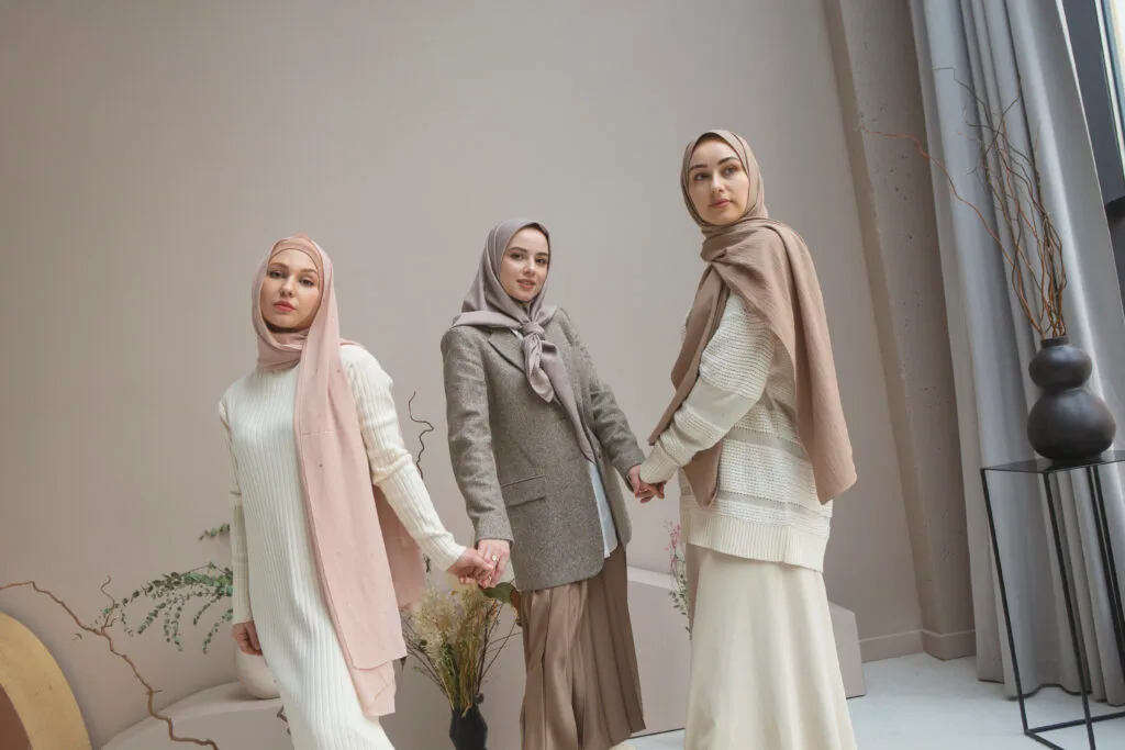 Trois femmes voilées, habillées modestement avec des robes, des jupes et des blazers. Lord d'un shootting photo pour boutique hijab lille