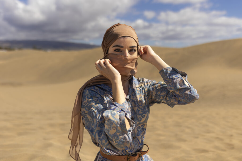 femme voilée dans le desert portant un hijab canicule,