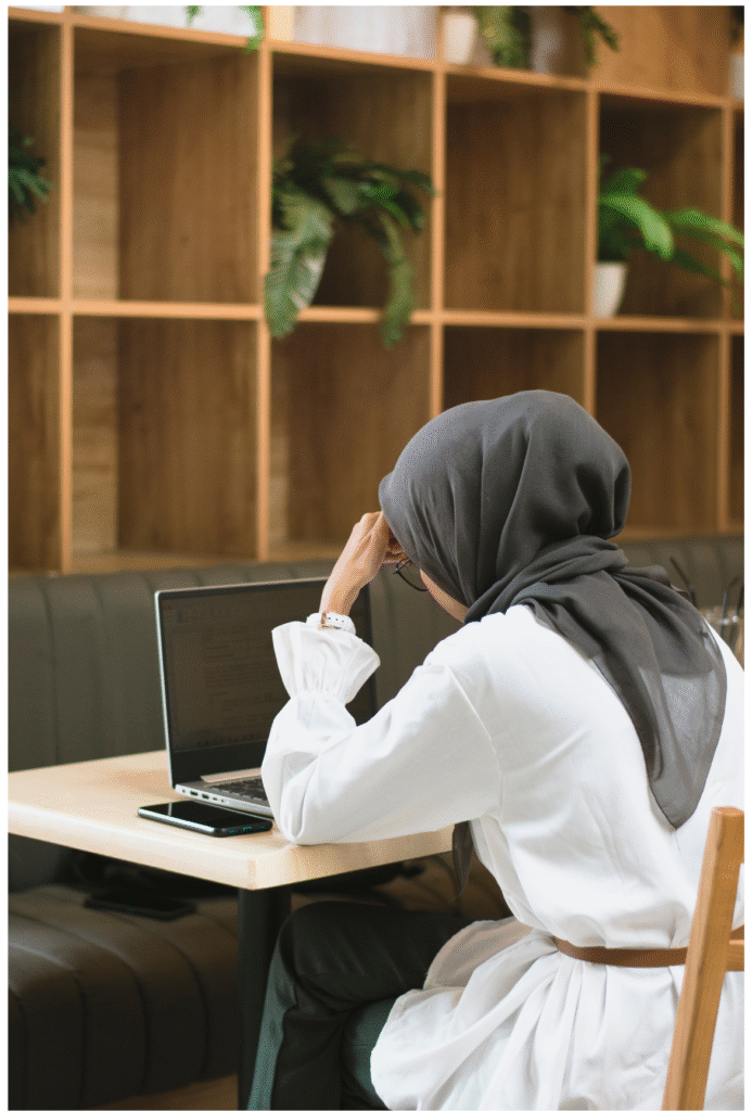 femme voilée dans une bibliothèque face à son ordinateur cherche des Invocation examen Islam 